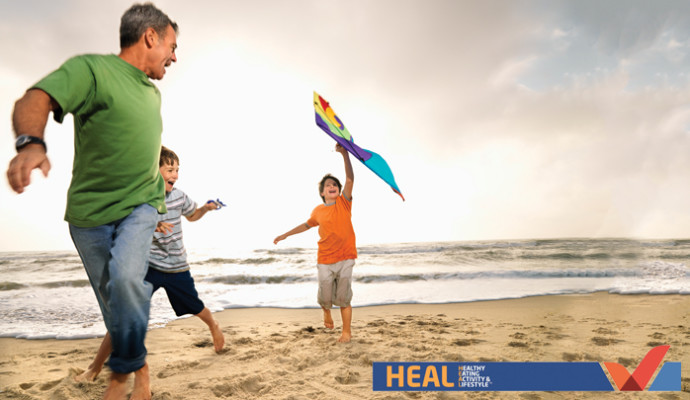 Dad playing with sons on the beach