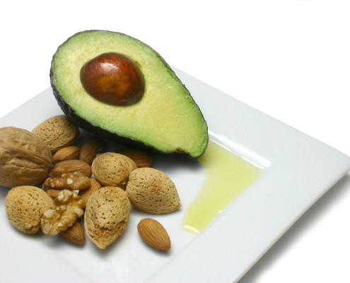 Avocado, nuts and olive oil on plate