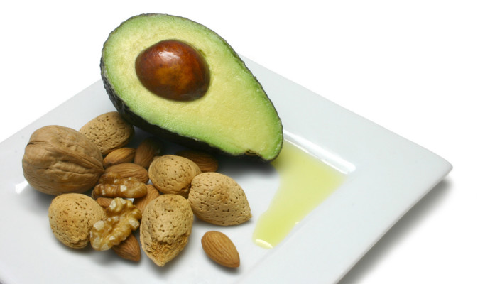 Avocado, nuts and olive oil on plate