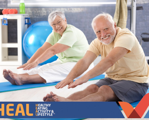 Older man and woman stretching in gym