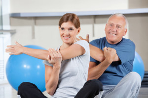 Man and woman stretching in gym