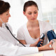 Doctor taking woman's blood pressure