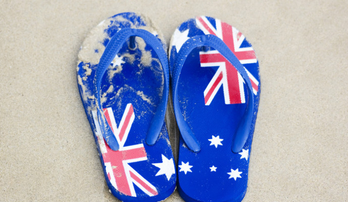 Thongs with Australian flag pattern on sand at beach