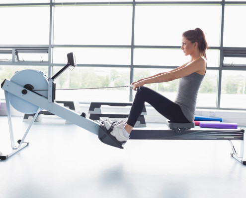 Woman on rowing machine in front of window