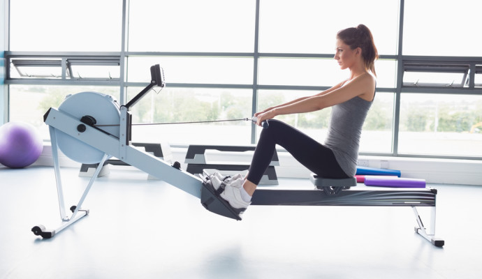 Woman on rowing machine in front of window