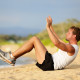 Man doing crunches on beach