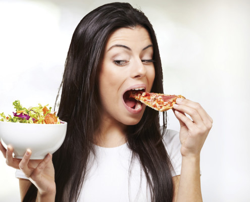 Woman eating pizza instead of salad