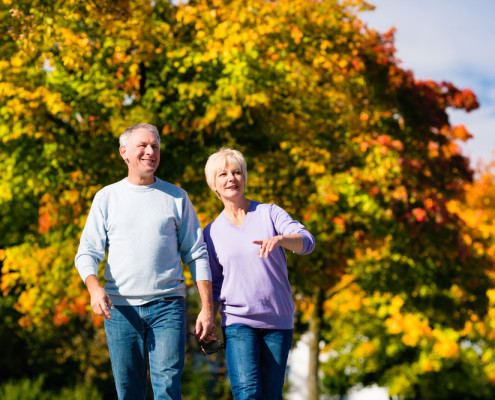 Older couple walking through park