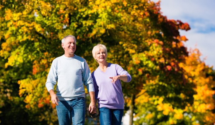 Older couple walking through park