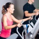 Woman and man training side by side on exercise equipment
