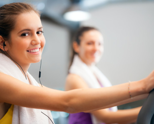 Woman on treadmill with earphones and towel