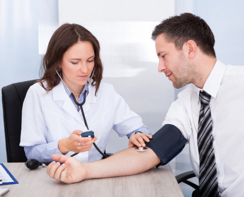 Nurse taking mans blood pressure