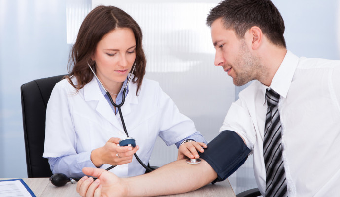 Nurse taking mans blood pressure